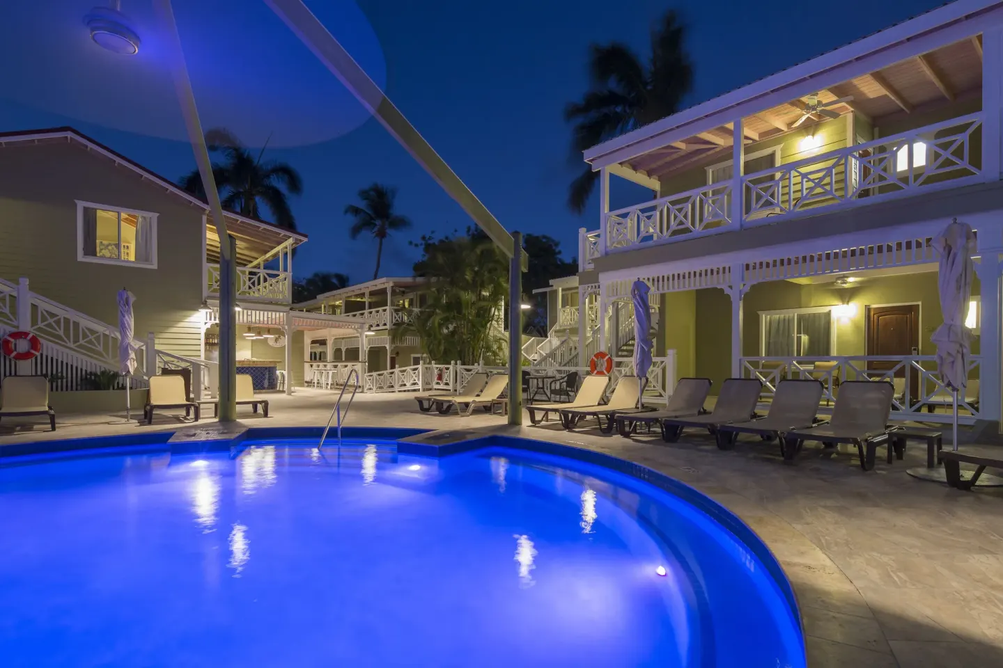 Evening pool area with loungers and guest buildings at Pineapple Beach Club Antigua.