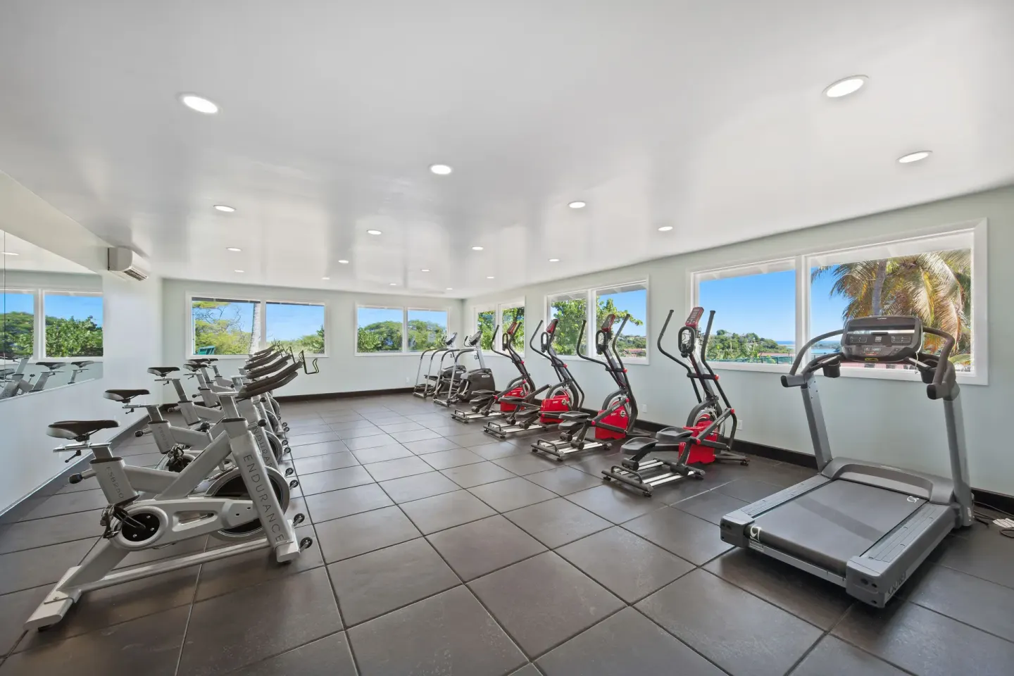 Fitness room with treadmills, bikes, and elliptical machines at Pineapple Beach Club Antigua.