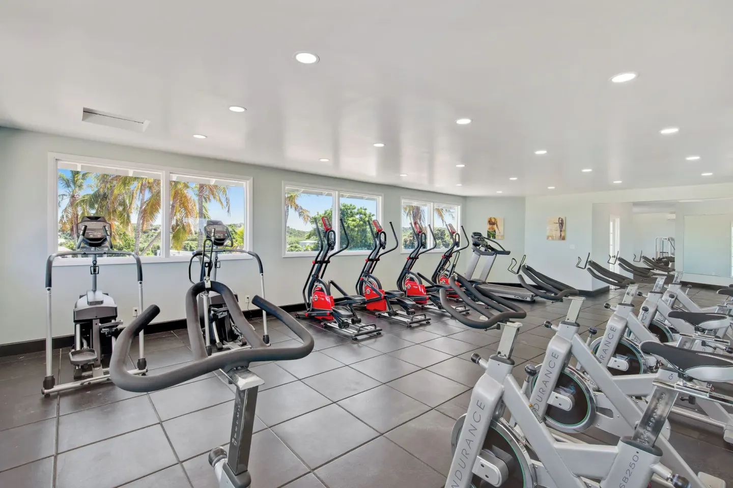 Fitness room with rows of exercise bikes and cardio machines at Pineapple Beach Club Antigua.