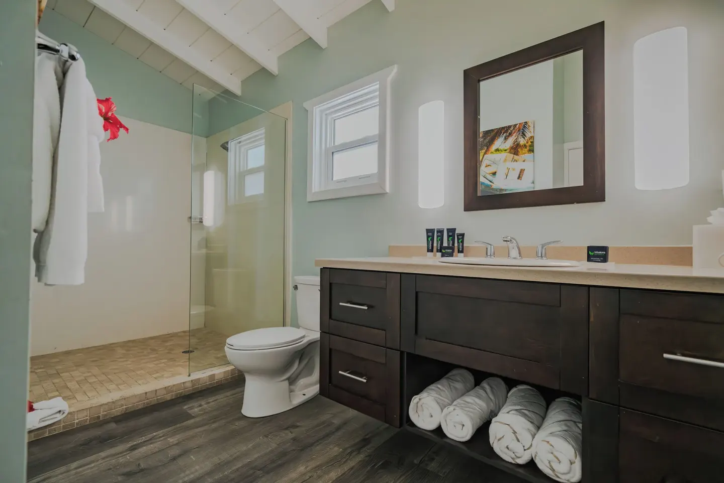 Guest bathroom with towels and glass shower at Pineapple Beach Club Antigua.