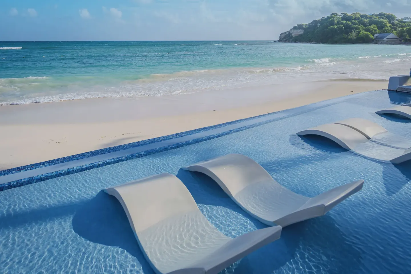 In-water loungers beside the beach at Pineapple Beach Club Antigua.
