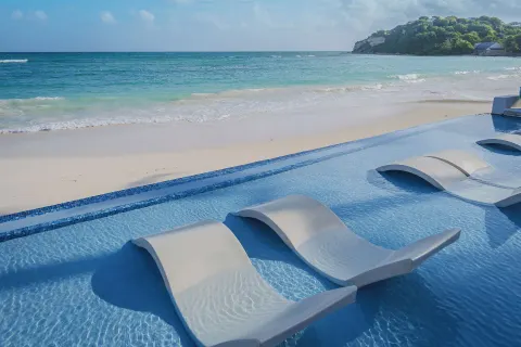 In-water loungers beside the beach at Pineapple Beach Club Antigua.