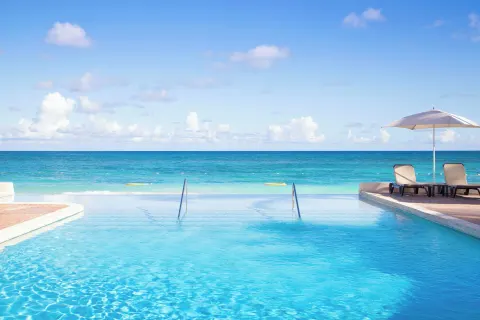 Infinity pool edge facing the turquoise sea at Pineapple Beach Club Antigua.