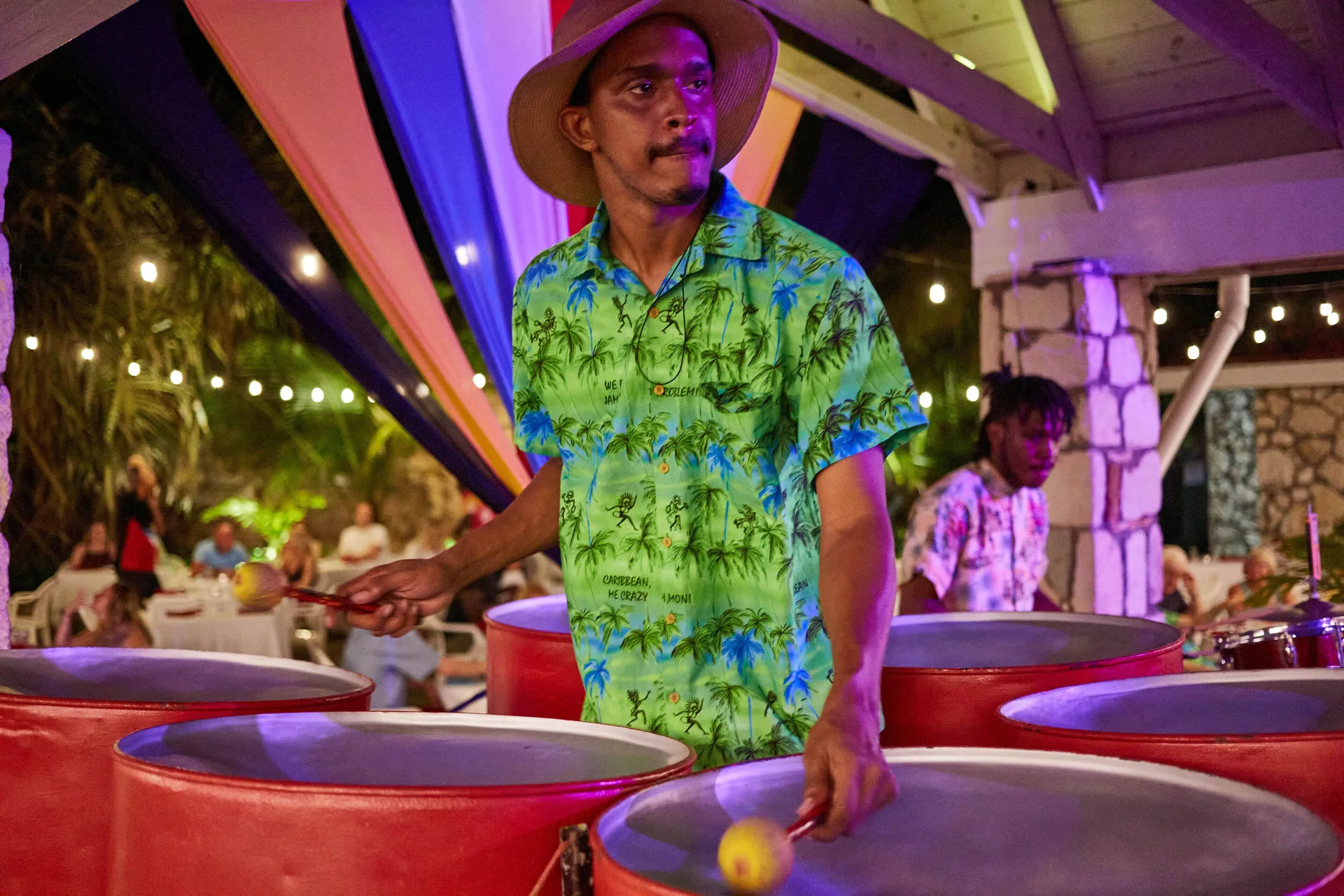 Steel pan musician performing under colorful lights at Pineapple Beach Club Antigua.