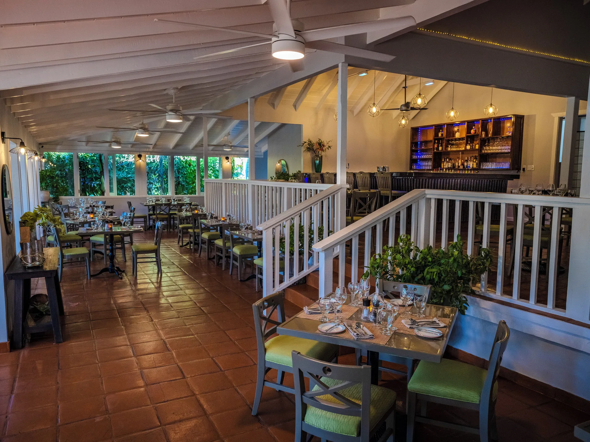 Restaurant dining room and bar with set tables at Pineapple Beach Club Antigua.