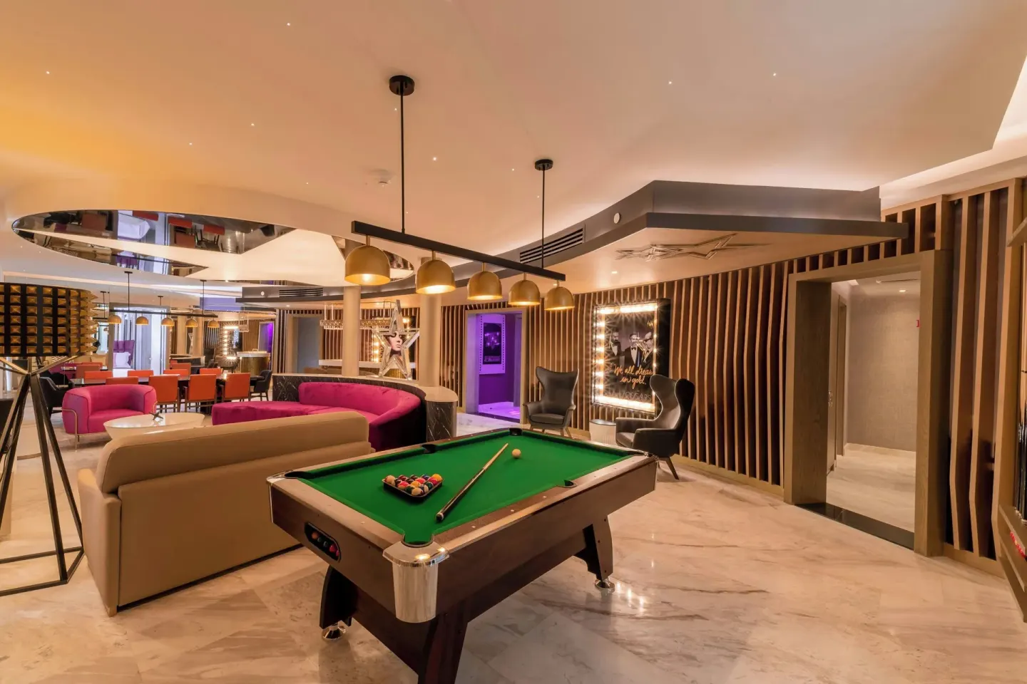 Indoor games lounge with a pool table and seating at Planet Hollywood Cancun.