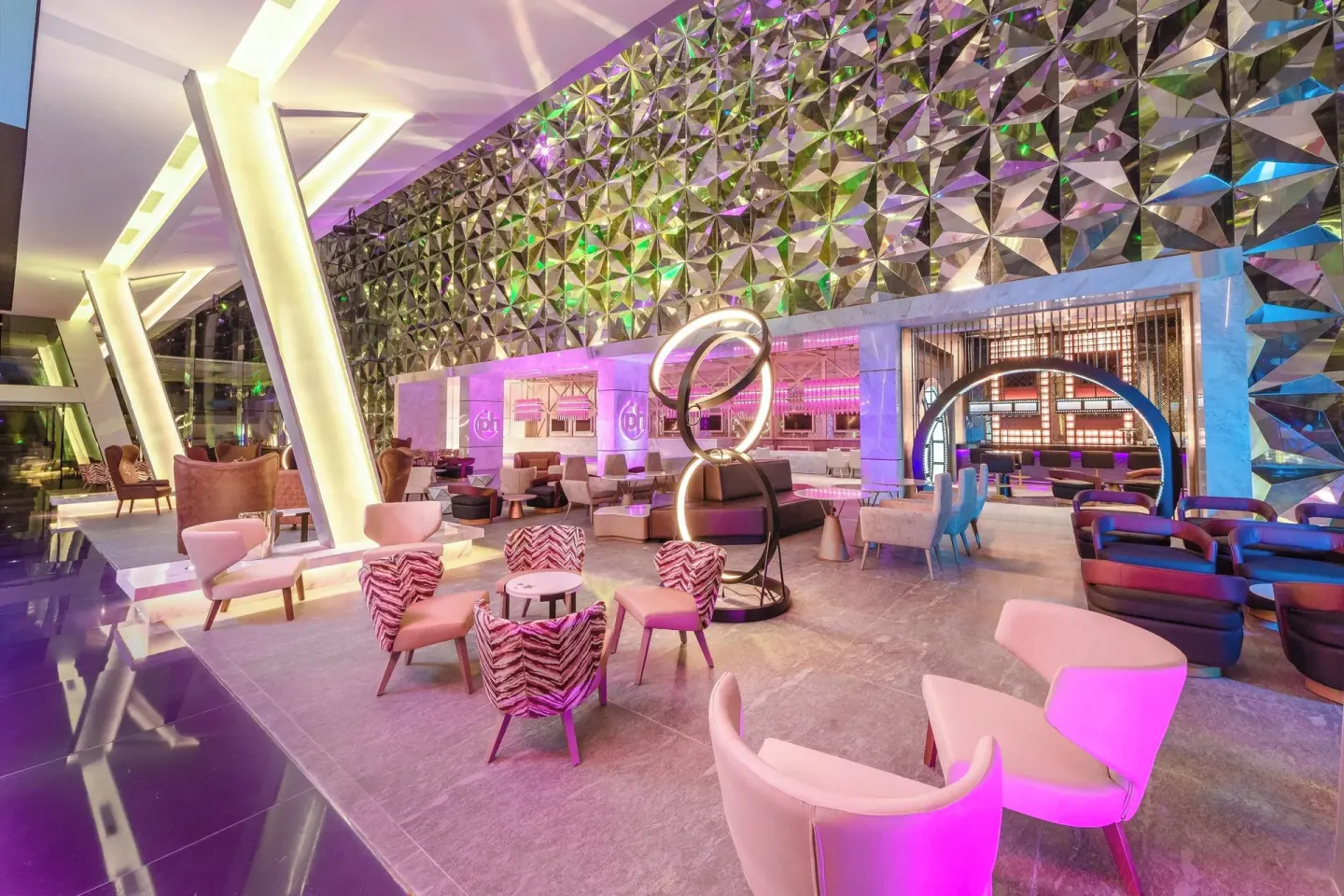 Spacious lobby lounge with colorful chairs and geometric wall panels at Planet Hollywood Cancun.