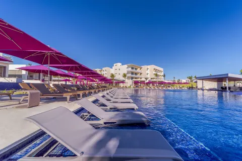 In-water loungers and purple umbrellas around a large pool at Planet Hollywood Cancun.