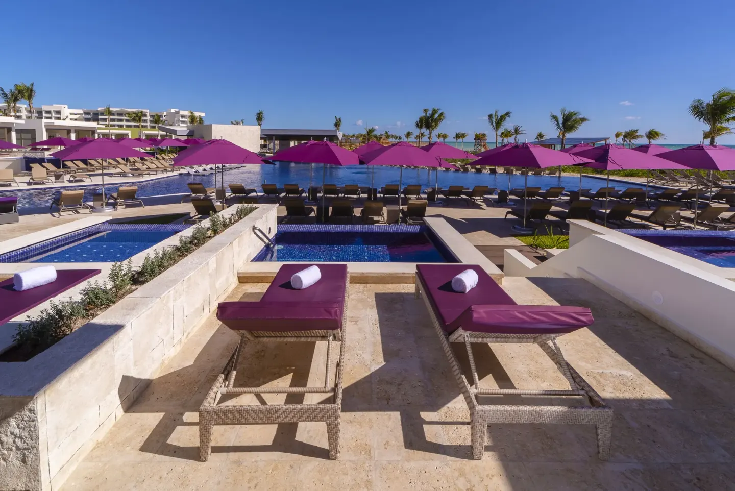 Private terrace loungers with towels facing the pool at Planet Hollywood Cancun.