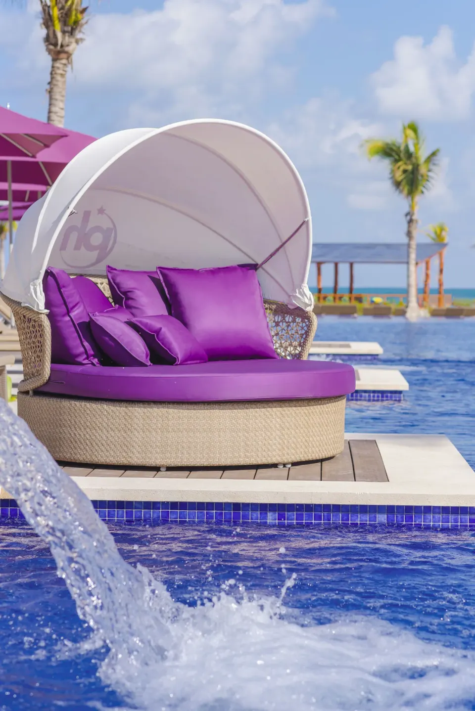 Purple cushioned daybed beside the pool at Planet Hollywood Cancun.