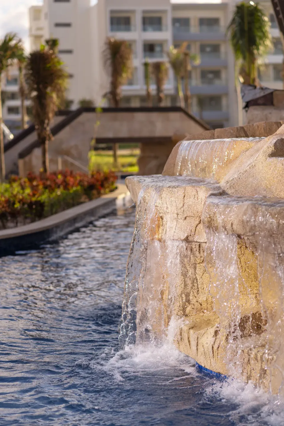 Rock waterfall flowing into a pool at Planet Hollywood Cancun.