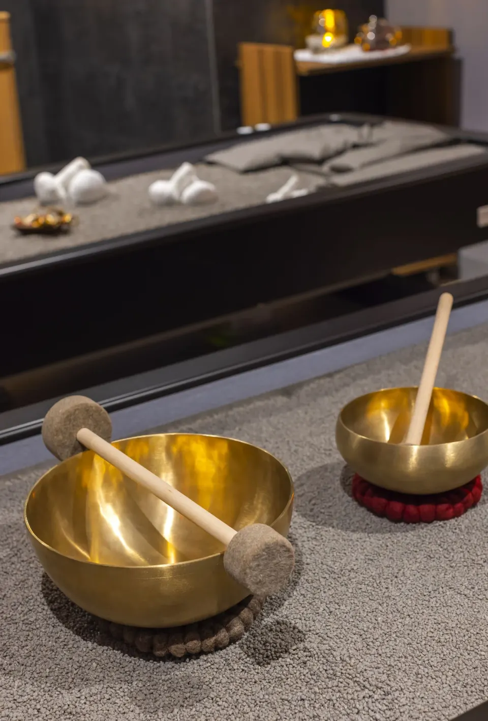 Singing bowls and mallets set on a spa treatment surface at Planet Hollywood Cancun.