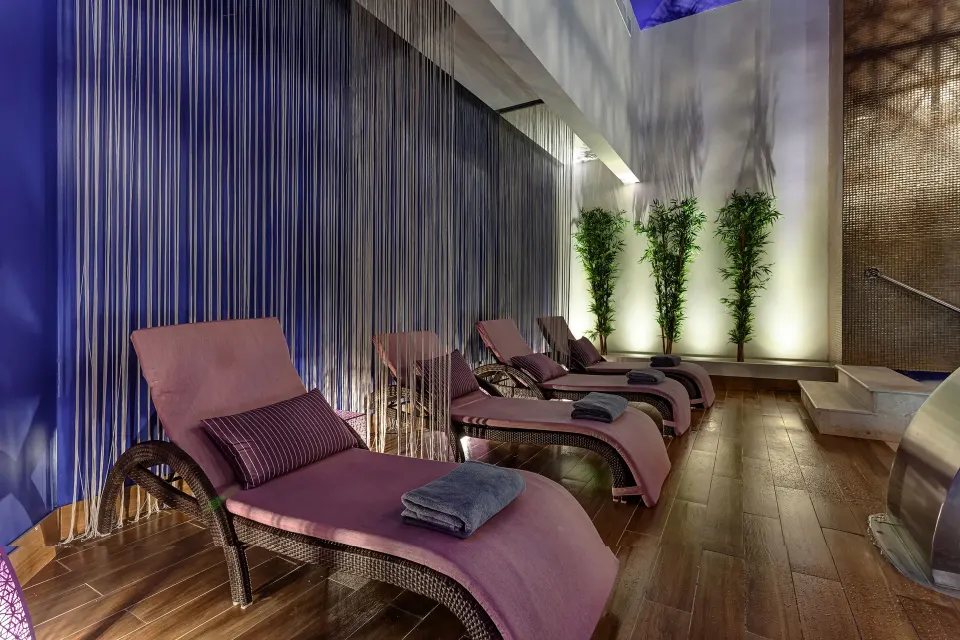 Spa relaxation room with pink loungers and folded towels at Planet Hollywood Cancun.