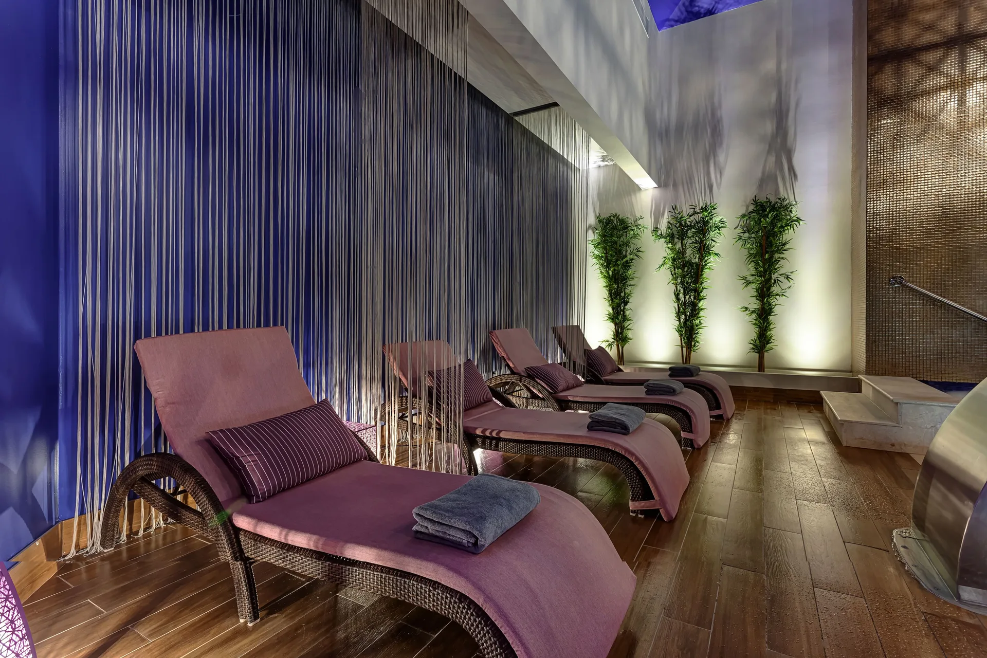 Spa relaxation room with pink loungers and folded towels at Planet Hollywood Cancun.
