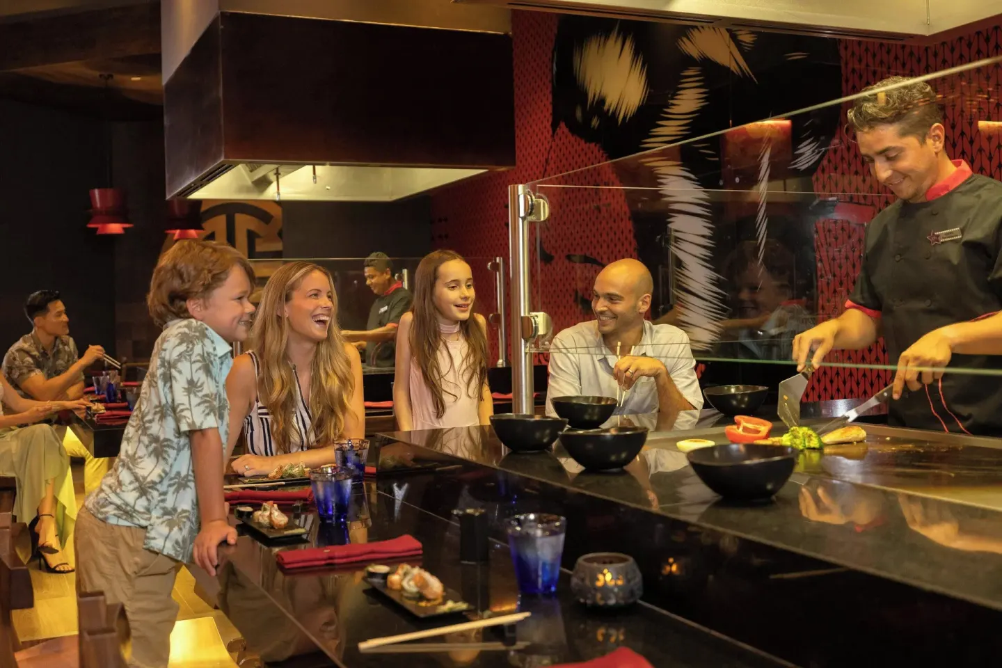Chef cooks at a teppanyaki grill for a family at Planet Hollywood Cancun.