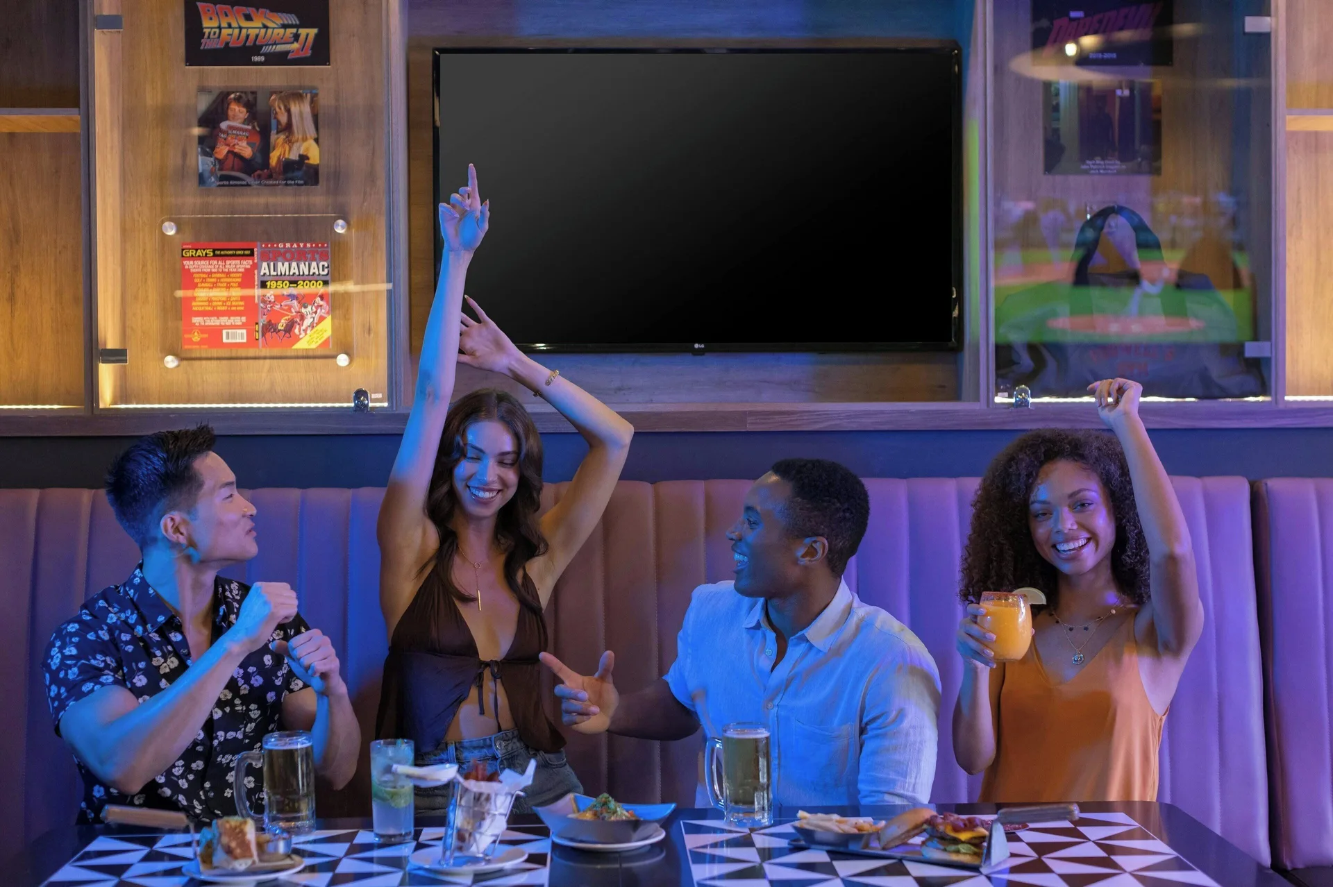 Guests dining and cheering in a sports bar setting at Planet Hollywood Cancun.