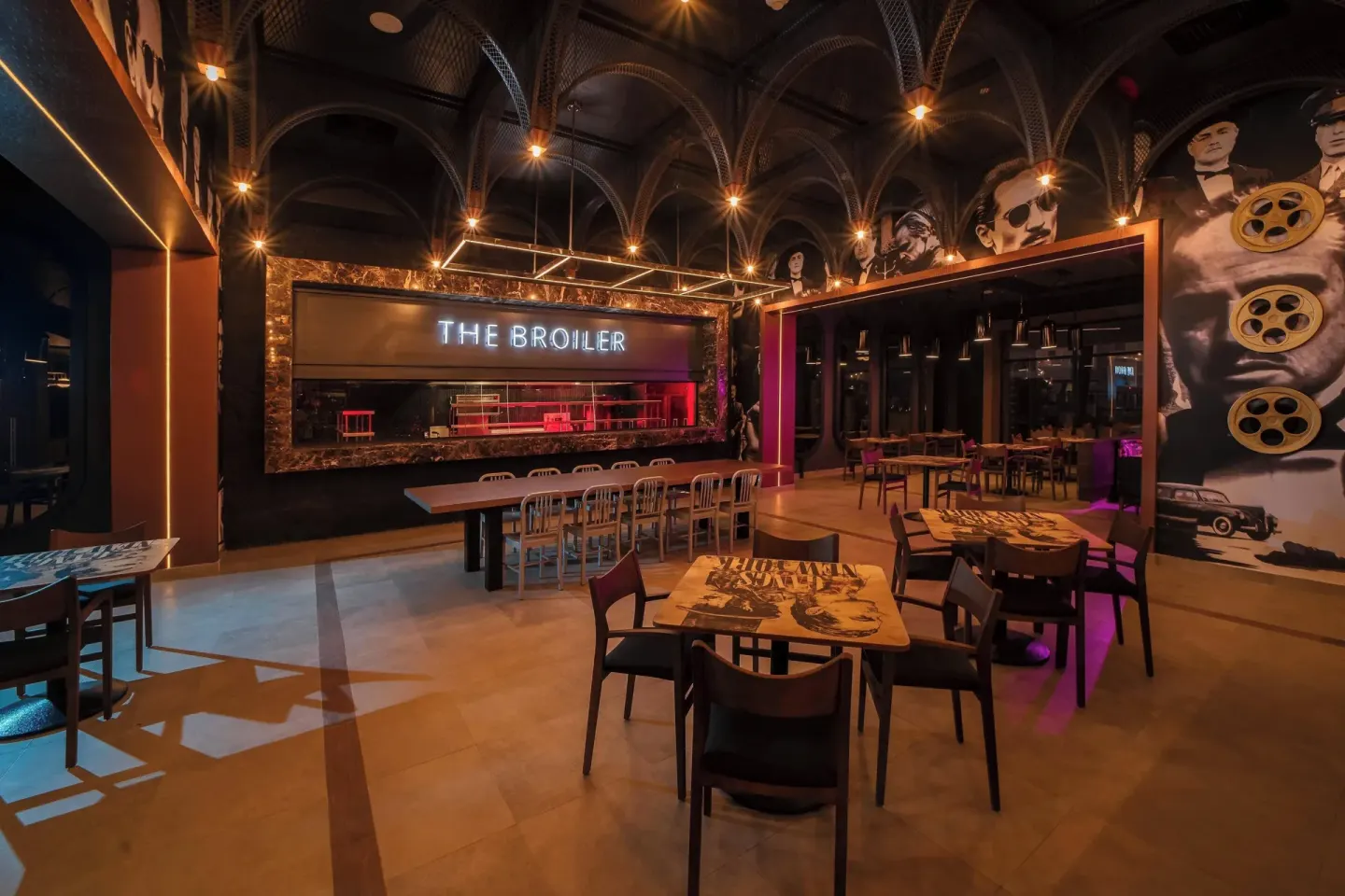 The Broiler dining room with open grill and movie murals at Planet Hollywood Cancun.