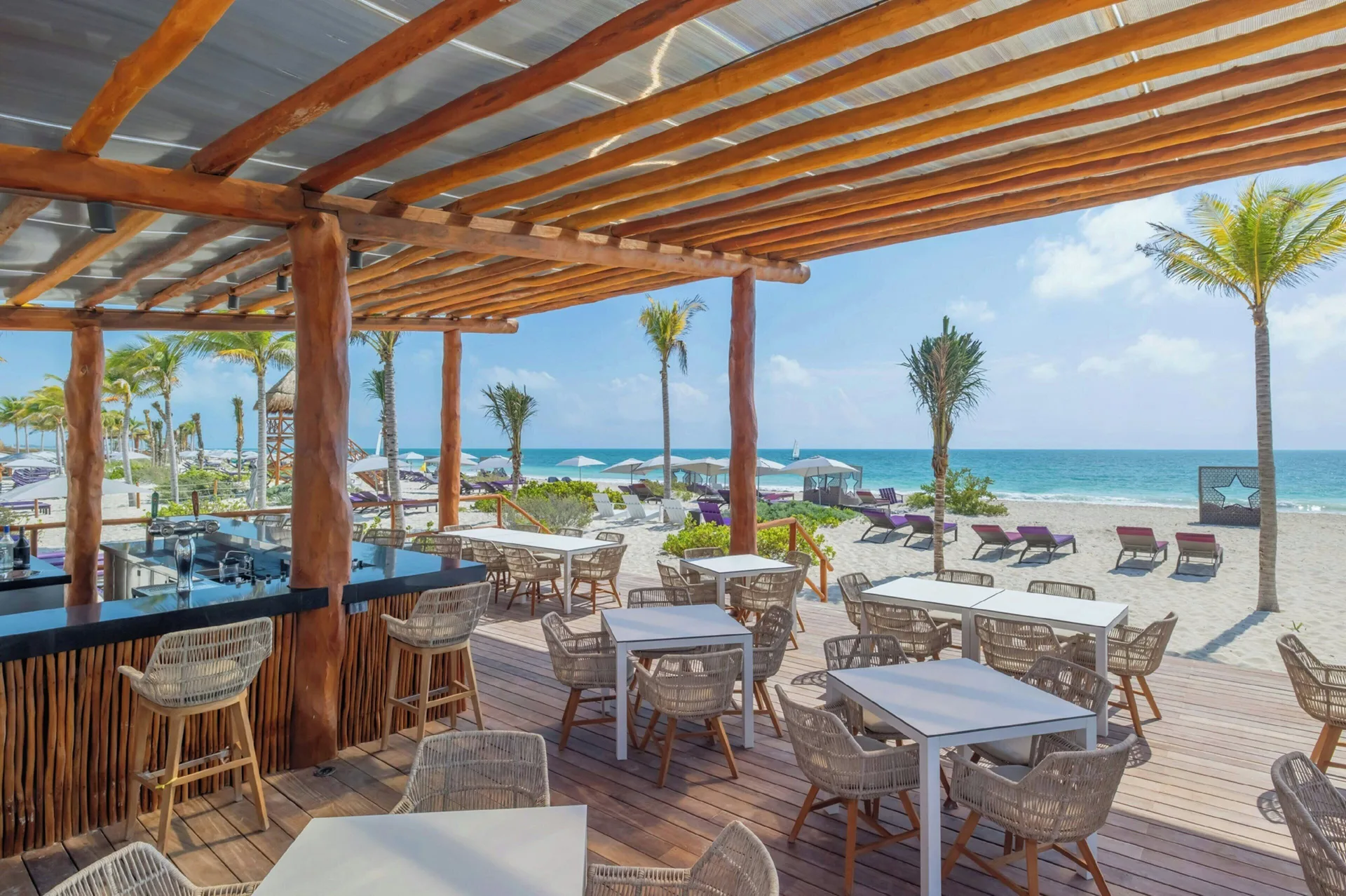 Open-air beach bar terrace with ocean views at Planet Hollywood Cancun.