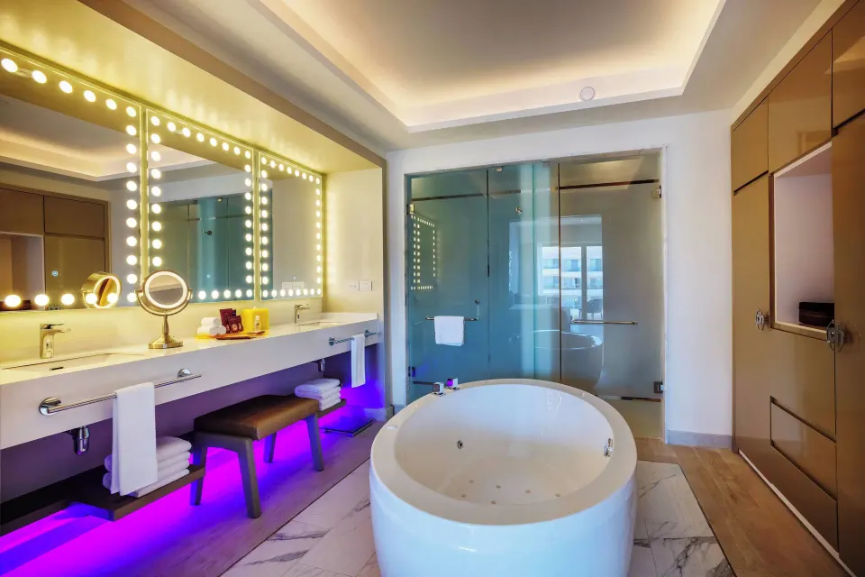 Directors Suite One Bedroom bathroom with soaking tub and lit vanity at Planet Hollywood Cancun.