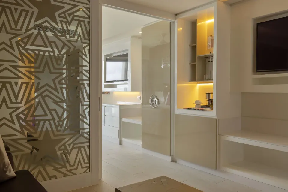 Entourage Suite entry area with patterned glass and minibar shelves at Planet Hollywood Cancun.