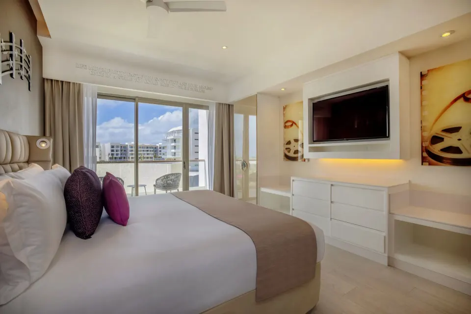 Entourage Suite king bed facing TV and balcony doors at Planet Hollywood Cancun.