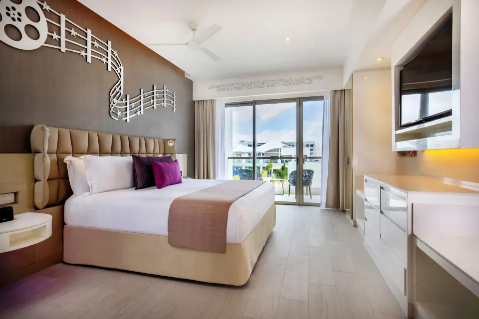 Entourage Suite king bed with balcony and TV wall at Planet Hollywood Cancun.