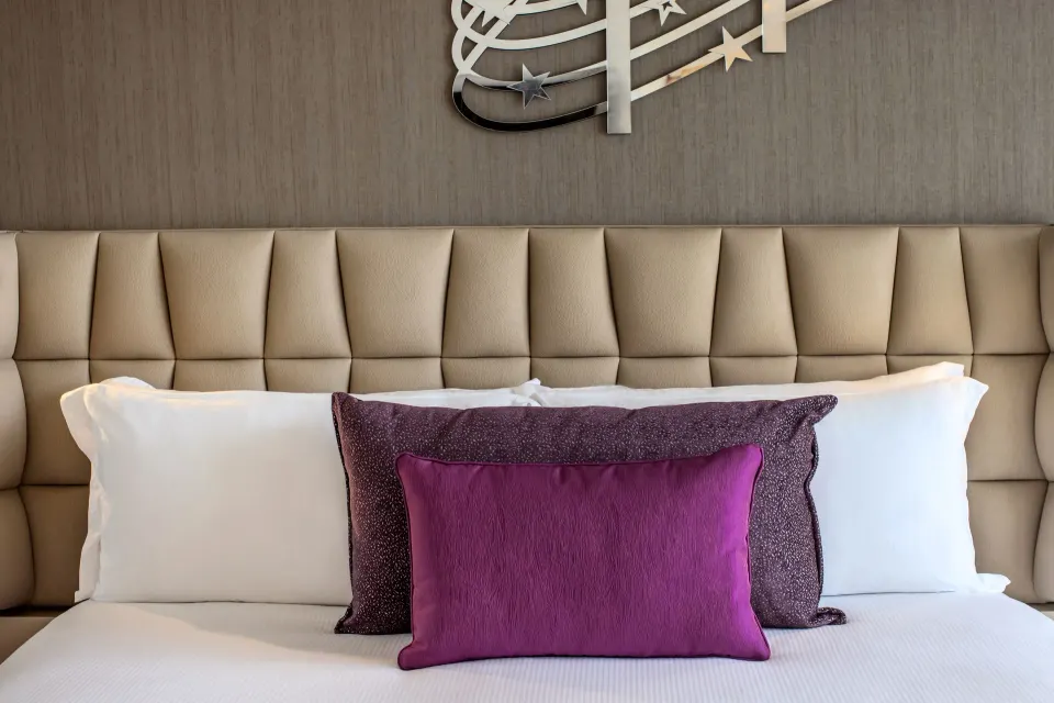 Entourage Suite king bed pillows and padded headboard at Planet Hollywood Cancun.