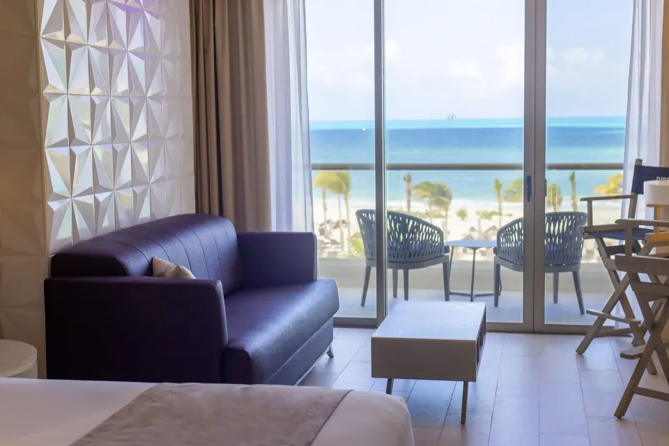 Junior Suite Ocean View seating area and balcony overlooking the beach at Planet Hollywood Cancun.