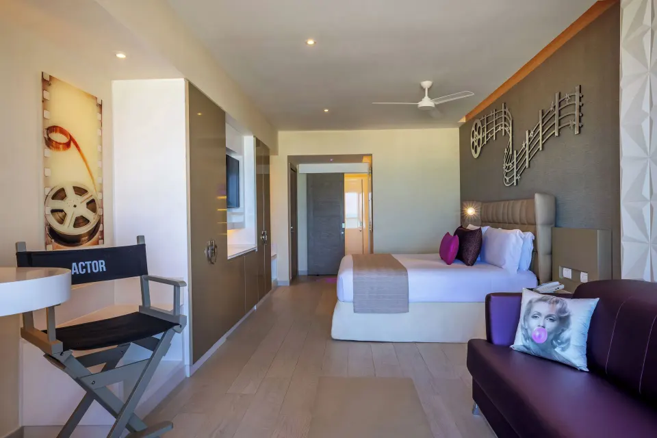 Junior Suite Ocean View with king bed, sofa, actor chair, and film decor at Planet Hollywood Cancun.