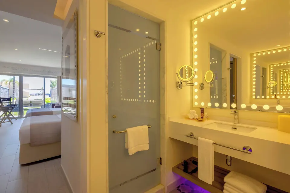 Bathroom vanity and glass shower in the Junior Suite Swim Out at Planet Hollywood Cancun.