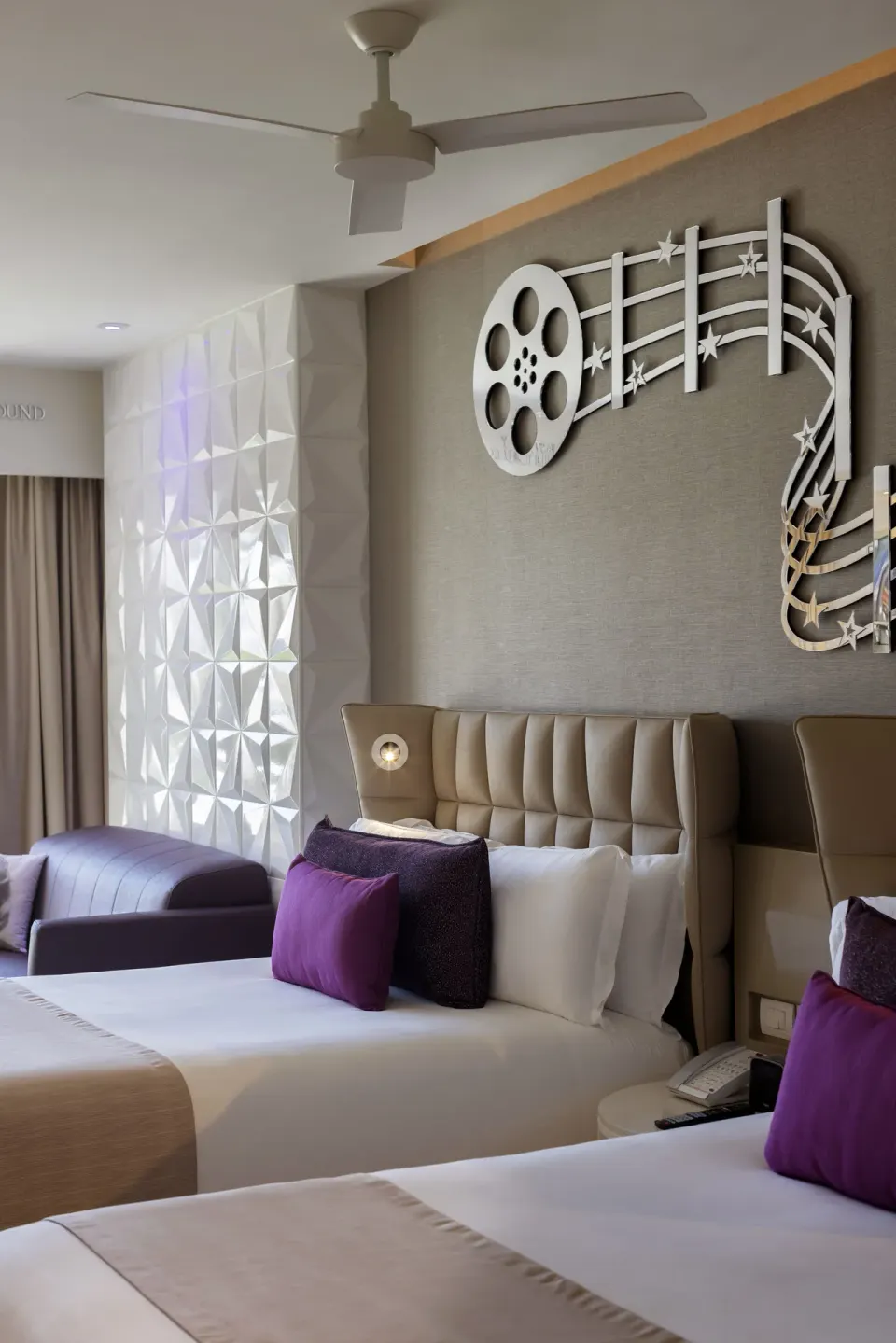Two beds with film-themed wall decor in the Junior Suite Swim Out at Planet Hollywood Cancun.