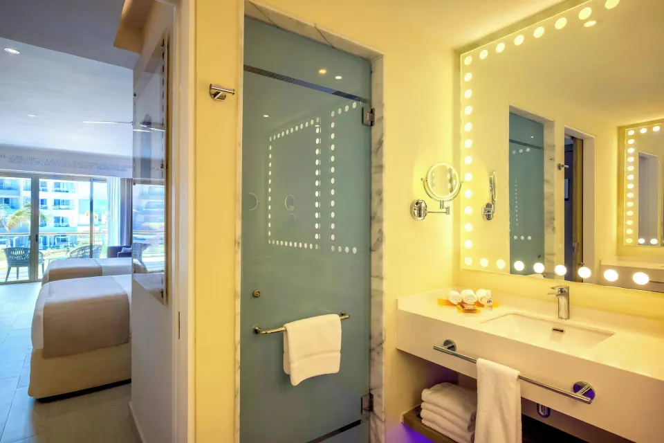 Junior Suite bathroom vanity and glass shower at Planet Hollywood Cancun.