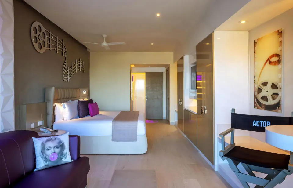 Junior Suite with one bed, sofa, film décor, and director chair at Planet Hollywood Cancun.