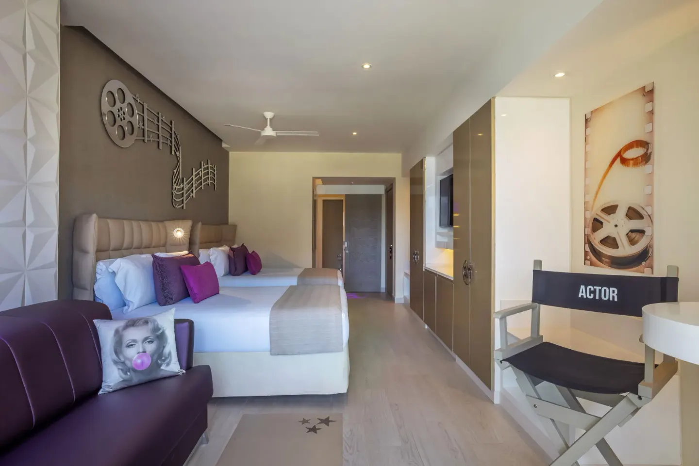 Junior Suite with two beds, sofa, and director chair at Planet Hollywood Cancun.