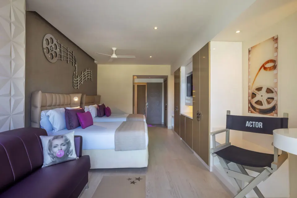 Junior Suite with two beds, sofa, and director chair at Planet Hollywood Cancun.