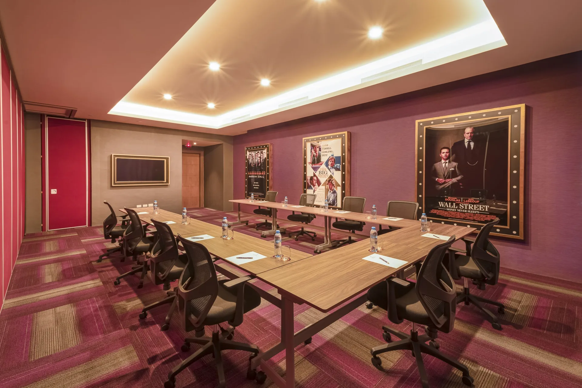 A boardroom setup with posters and conference tables is shown at Planet Hollywood Cancun.
