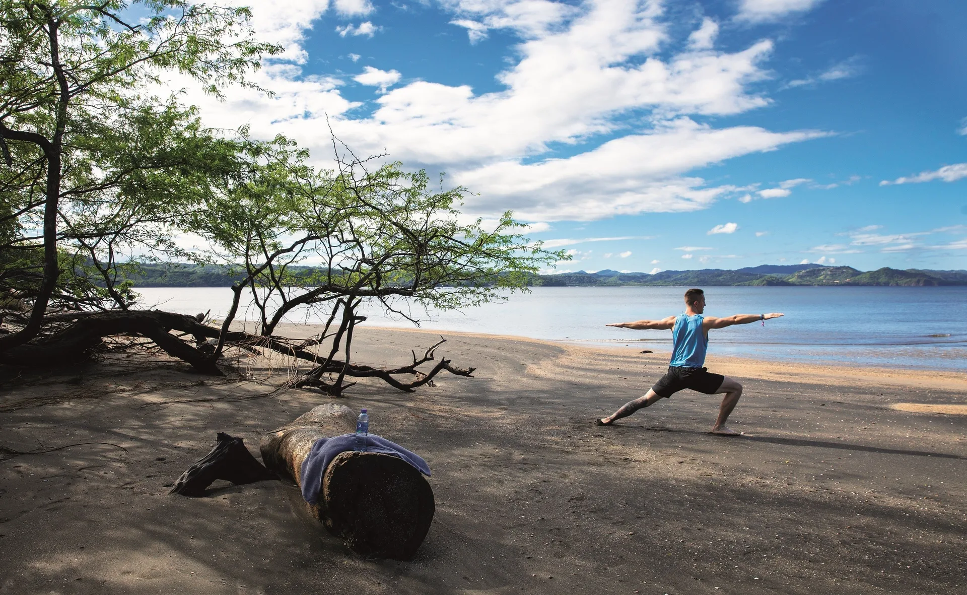 Beach yoga pose beside calm water at Planet Hollywood Costa Rica.