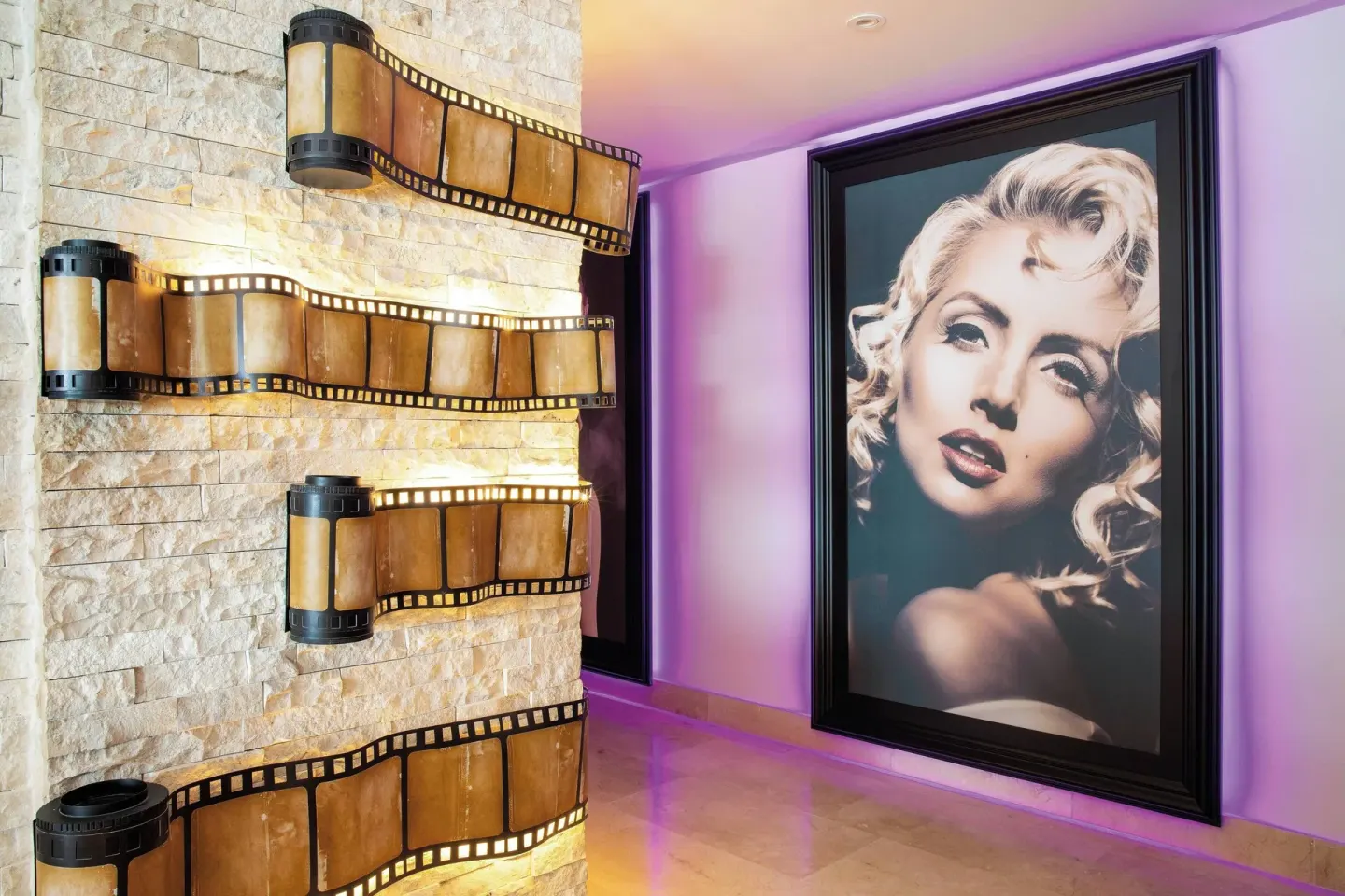 Resort hallway with filmstrip wall art and a large portrait at Planet Hollywood Costa Rica.