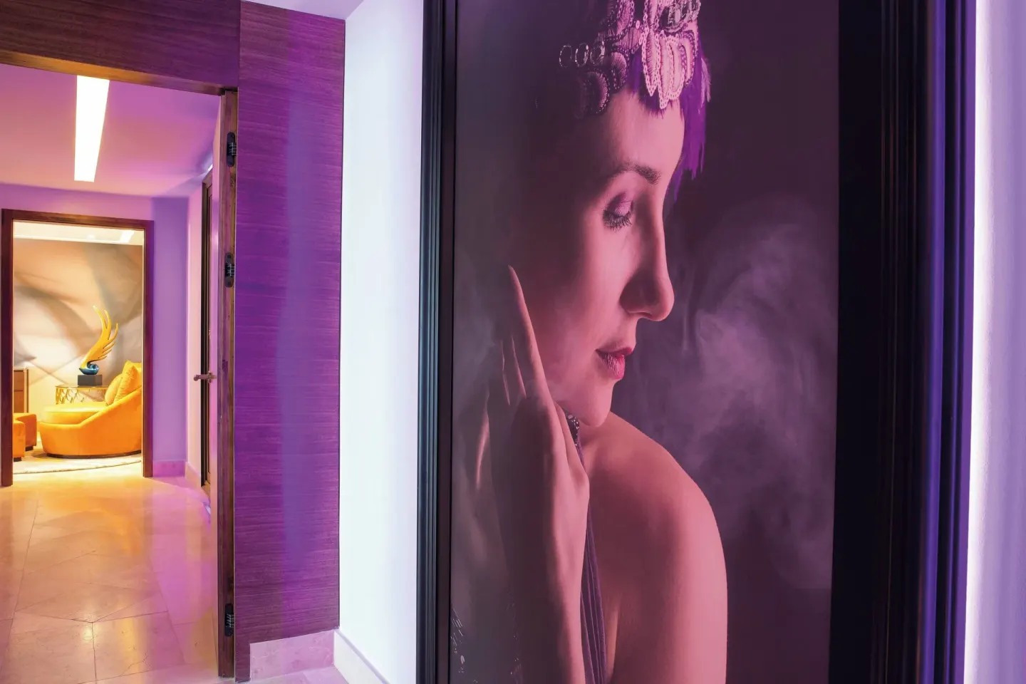 Purple-lit guest room corridor with portrait art at Planet Hollywood Costa Rica.