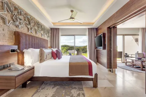 King bed guest room with star wall decor and balcony view at Planet Hollywood Costa Rica.