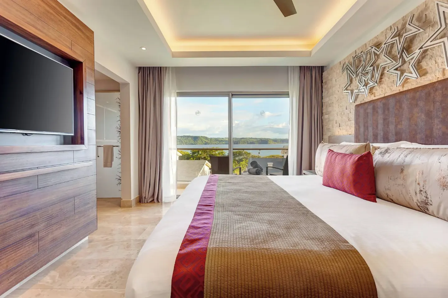 King bed guest room with balcony and water view at Planet Hollywood Costa Rica.