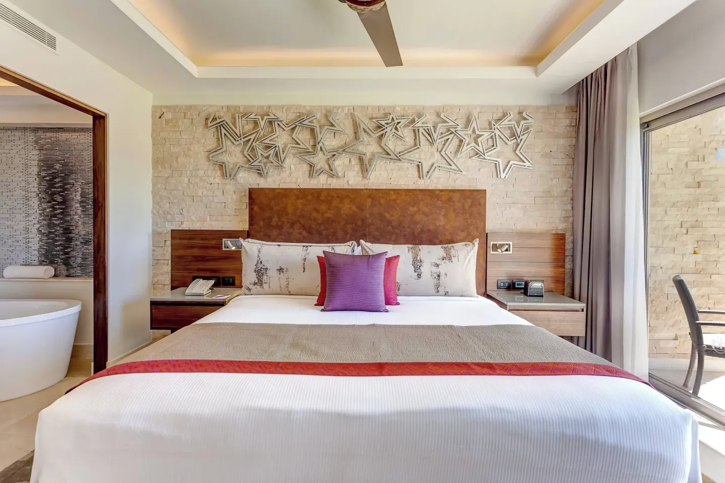 King bed with star wall art in a guest room at Planet Hollywood Costa Rica.