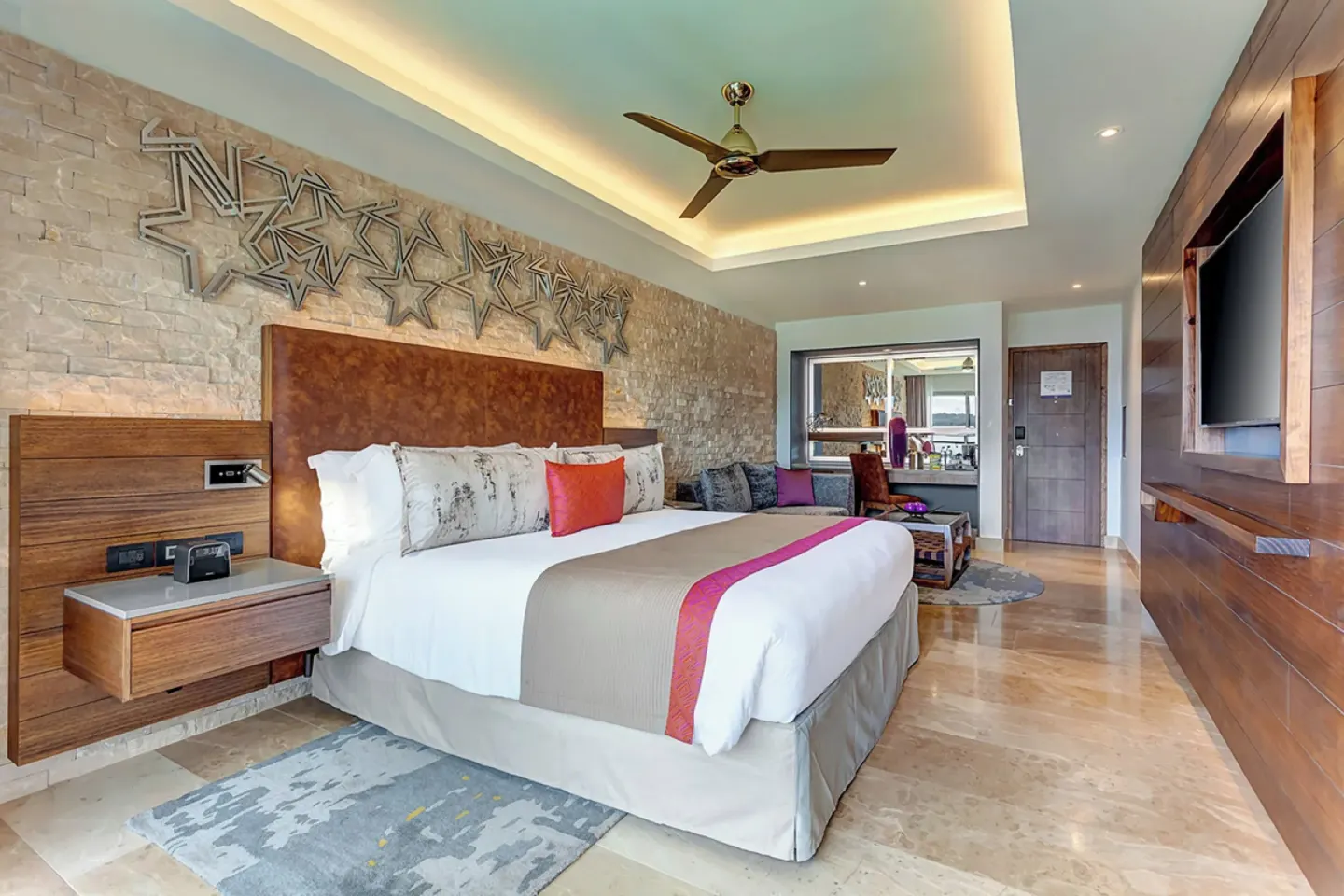 King bed guest room with star wall decor and seating area at Planet Hollywood Costa Rica.