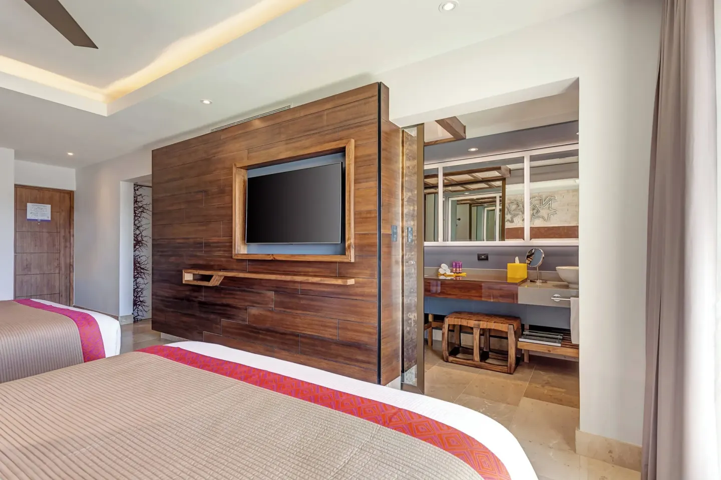 Two-bed guest room with TV wall and open vanity at Planet Hollywood Costa Rica.
