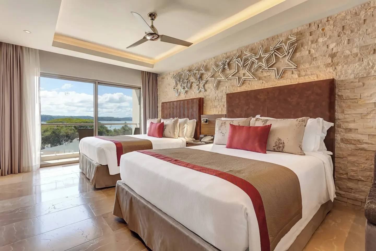 Two queen beds with balcony and water view at Planet Hollywood Costa Rica.