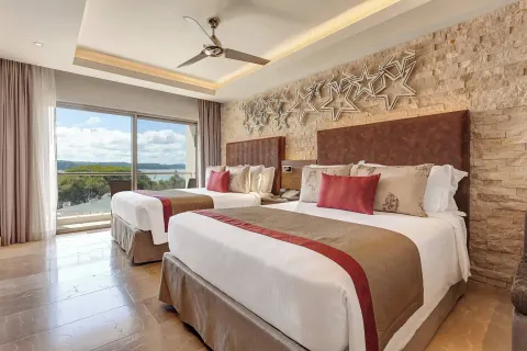 Two queen beds with balcony and water view at Planet Hollywood Costa Rica.