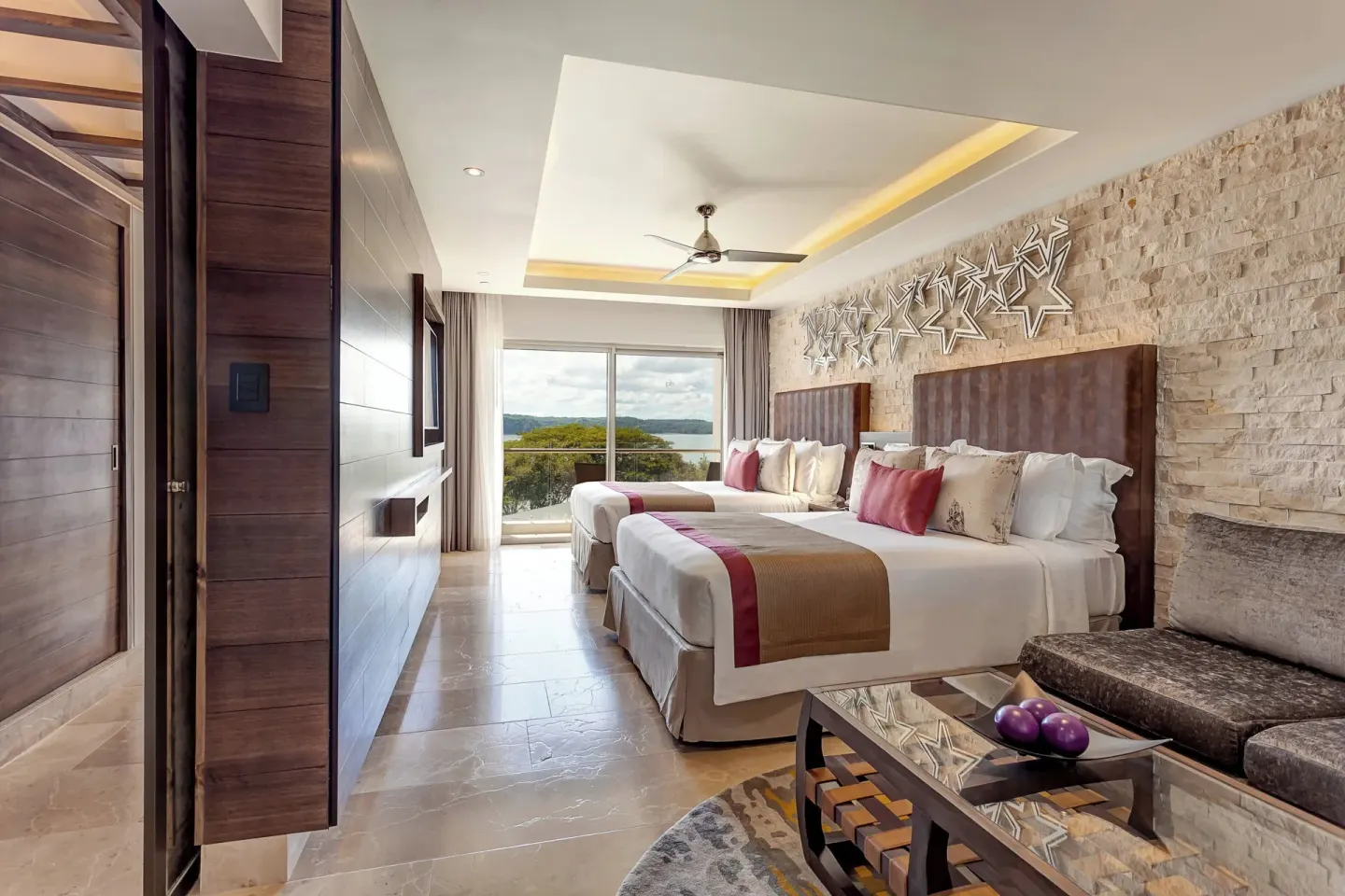 Two queen beds and sitting area in a guest room at Planet Hollywood Costa Rica.