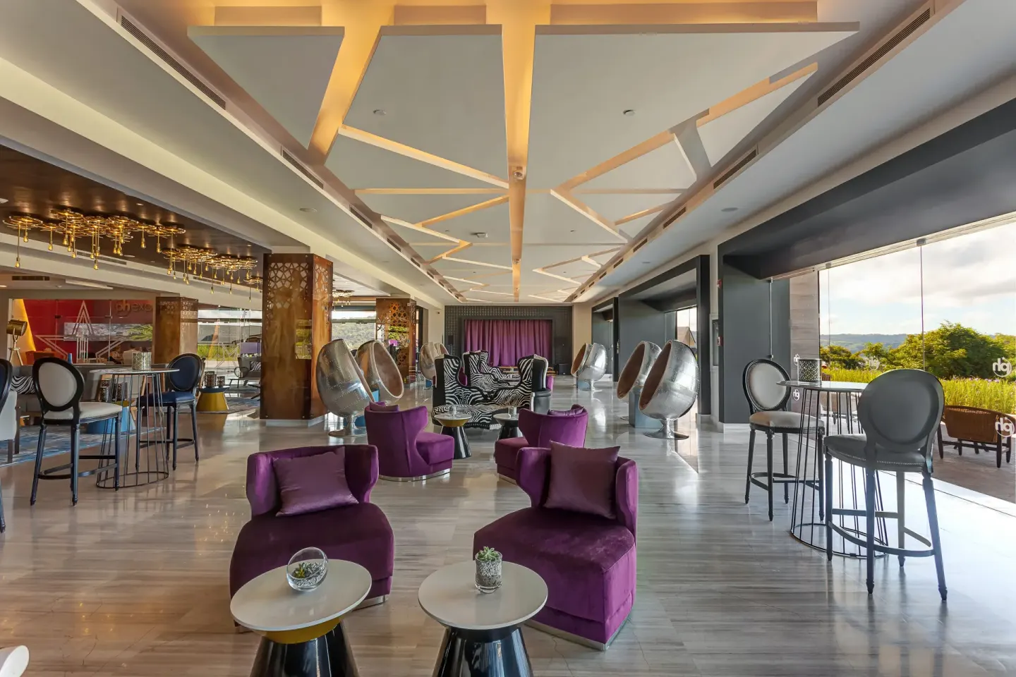 Open lobby lounge with purple chairs and balcony views at Planet Hollywood Costa Rica.
