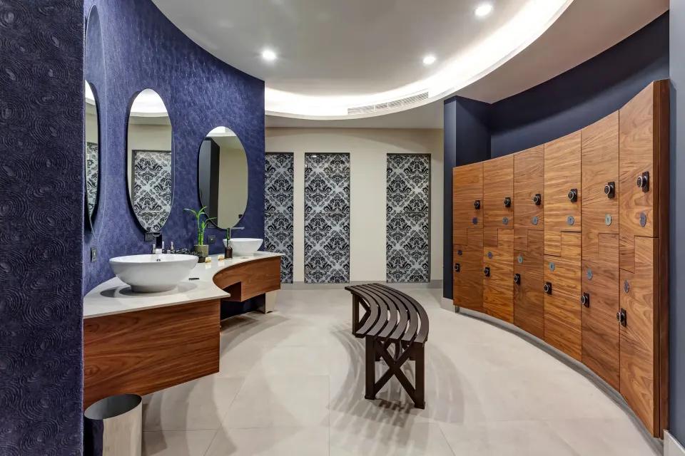 Spa locker room with sinks, mirrors and wood lockers at Planet Hollywood Costa Rica.