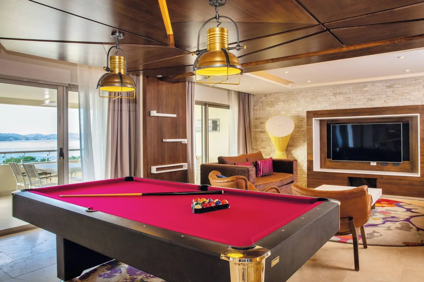 Suite game room with a red pool table and bay-view balcony at Planet Hollywood Costa Rica.